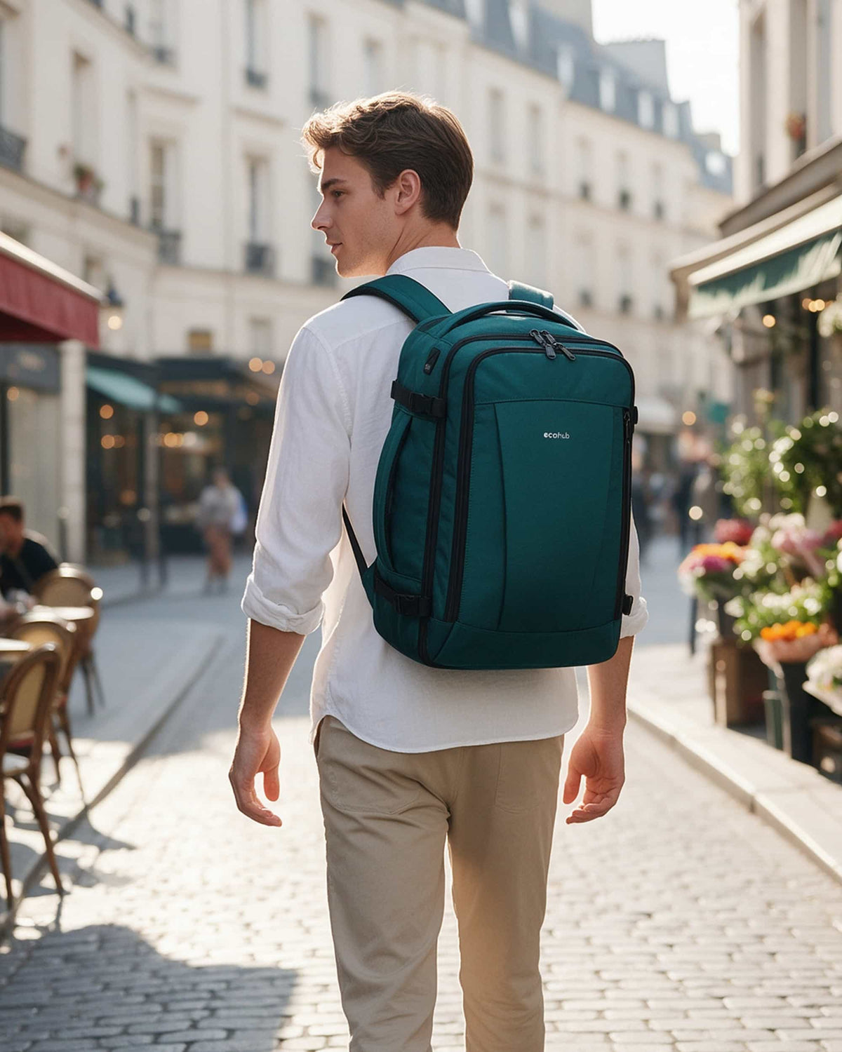 Traveler wearing a blue green carry-on travel backpack