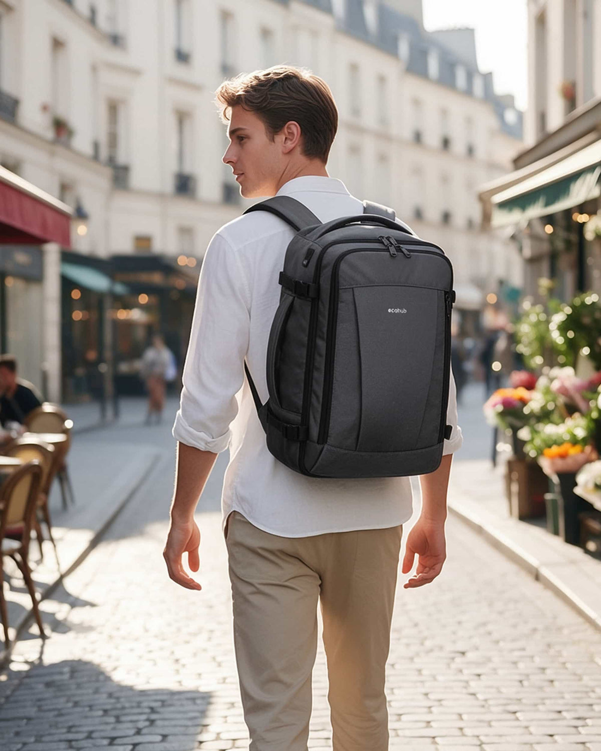 Traveler wearing a light gray carry-on travel backpack